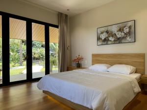 a bedroom with a large bed and a large window at Annhien home's in Ấp Long Thạnh