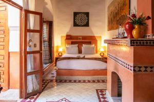 um quarto com uma cama e uma lareira em Riad Alili em Marraquexe