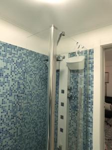 a bathroom with a shower with blue tiles at CityView in Latina