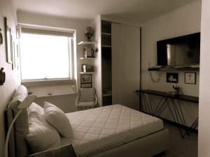 a bedroom with a white bed and a window at CityView in Latina