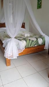 a bed with a canopy in a room at Meme Royak Homestay in Munduk