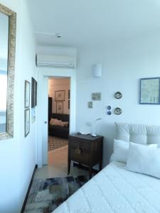 a white bedroom with a bed and a table at CityView in Latina