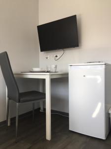 a computer desk with a chair and a monitor on a wall at Einzelzimmer mit Bad in Zwickau