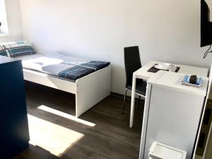 a small room with a bed and a desk at Einzelzimmer mit Bad in Zwickau