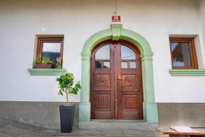een gebouw met een houten deur en een potplant bij Apartments Pr' Pavleto in Bohinj