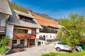 een rij huizen met een auto geparkeerd op een parkeerplaats bij Apartments Pr' Pavleto in Bohinj