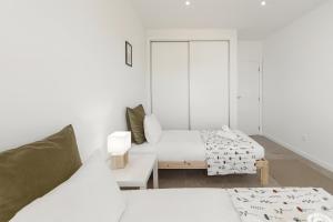a white room with two beds and a couch at Villa Lagoa in Vau