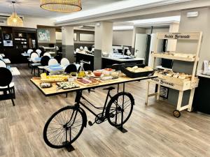 una bicicleta estacionada frente a una panadería con comida en una mesa en Summer Hotel, en Calella