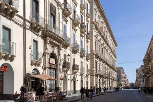 een groep mensen die in een straat naast gebouwen lopen bij Palazzo Costarelli - Bed and Breakfast in Catania