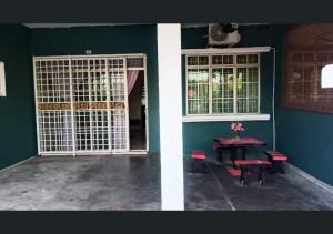 um quarto com uma mesa e uma porta e uma mesa e cadeiras em Jalinan Qaseh Homestay em Seri Manjung