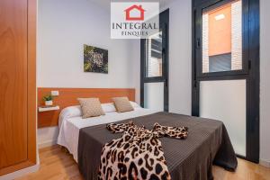 a bedroom with a bed with a leopard blanket on it at Dive Palamós in Palamós