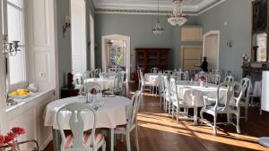 a dining room with white tables and white chairs at Schloss Schlemmin in Schlemmin