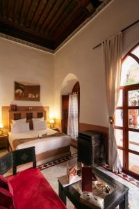 um quarto com uma cama king-size e uma lareira em Riad Alili em Marraquexe