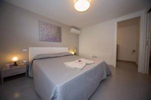 a bedroom with a large white bed with a towel on it at Palazzina Cala Luna Suite in San Benedetto del Tronto