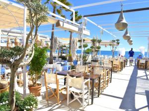 un restaurante en la playa con mesas y sillas en Casa Liberty Javea, en Jávea