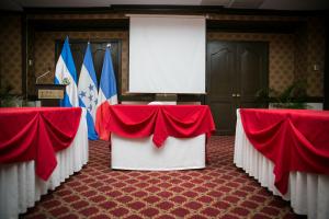 ein Konferenzraum mit roten und weißen Tischen und Flaggen in der Unterkunft Best Western Plus Hotel Terraza in San Salvador + 82 Fotos