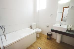 La salle de bains est pourvue d'une baignoire, de toilettes et d'un lavabo. dans l'établissement AMMOTTI Hotel and Apartments, à Ohrid