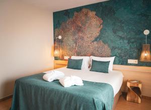 1 dormitorio con 1 cama con toallas en htop Amaika & SPA 4Sup - Adults Only #htopBliss, en Calella
