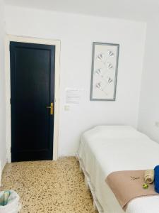 a bedroom with two beds and a black door at Habitacion RUSTICA en Palma para una sola persona en casa familiar in Palma de Mallorca
