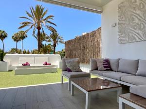 un soggiorno con divano e tavolo di Las Americas Luxury Low-Cost Apartment with Terrace & Views a Playa de las Americas