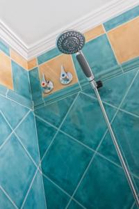 a shower in a bathroom with blue tiles at Boutique Hotel Pueblo in Benalmádena