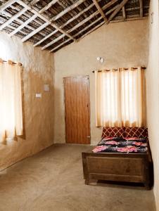 pusty pokój z łóżkiem i drewnianymi drzwiami w obiekcie Cosmic Mud House Kanthalloor w mieście Kanthalloor