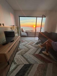 een vrouw op een bank in een woonkamer met een laptop bij CUSTÓDIO SEA HOME in Praia de Mira