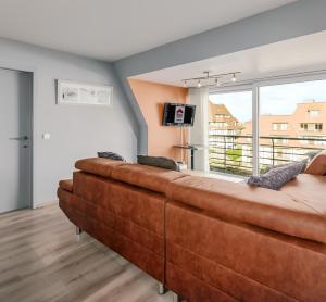 - un grand canapé brun dans le salon avec une fenêtre dans l'établissement Neoportus B 0401p-2-209, à Nieuport