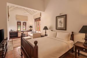 a bedroom with a large bed and a living room at Uga Riva Negombo in Negombo