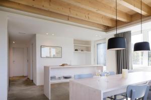 カッペルンにあるFjordhaus an der Schlei, Wohnung 6 Personenの白いテーブルと椅子のあるキッチンとダイニングルーム