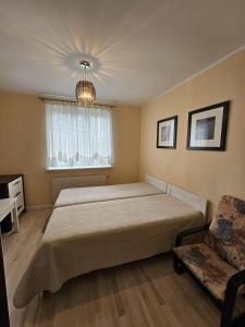 a bedroom with a bed and a couch and a window at Villa Krystyna in Dźwirzyno