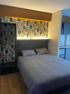 uma cama com duas almofadas num quarto em Smart Appart Le Havre 105 em Le Havre