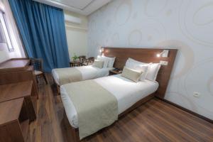 een hotelkamer met 2 bedden en een bureau bij Olympic Inn Casablanca in Casablanca