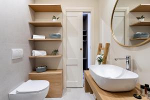 een badkamer met een wastafel, een toilet en een spiegel bij Palazzo Costarelli - Bed and Breakfast in Catania +28 foto's