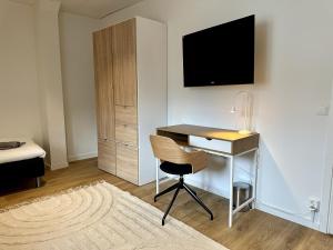 um quarto com uma secretária, um computador e uma cama em Attic Living Hostel em Borås