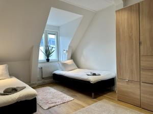 een slaapkamer met 2 bedden en een raam bij Attic Living Hostel in Borås