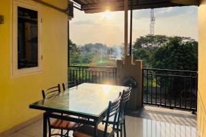 een tafel en stoelen op een balkon met uitzicht bij RedDoorz At Teratai Homestay Medan Amplas in Medan