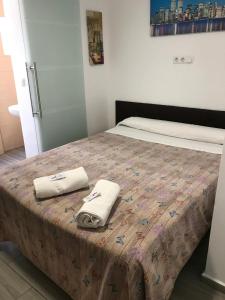 a bedroom with a bed with two towels on it at La Ferroviaria - Habitaciones Con Baño Privado y Compartido - Sin Ascensor in Zaragoza