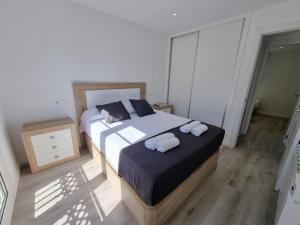 a bedroom with a bed with two towels on it at VibesMalpica - Canido 12 in Malpica