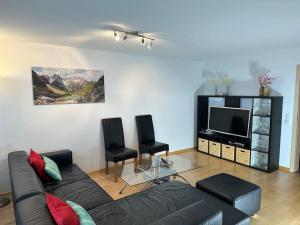 a living room with a couch and a tv at Ferienwohnung Bodenseeblick in Hagnau