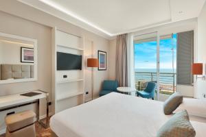 マリーナ・ディ・マッサにあるHotel Excelsiorのベッド付きのホテルルームで、海の景色を望めます。