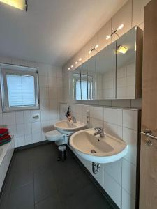Baño con 2 lavabos y espejo en Ferienwohnung Bodenseeblick, en Hagnau