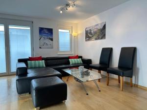 ein Wohnzimmer mit einem Sofa, 2 Stühlen und einem Tisch in der Unterkunft Ferienwohnung Bodenseeblick in Hagnau