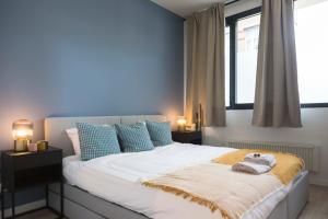 een slaapkamer met een groot bed met blauwe muren bij Brussels EU Design Residence in Brussel