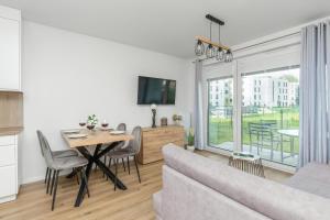 a living room with a table and a couch at Cosy Apartment with Terrace and Parking in Rumia by Rent like home in Rumia