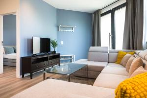 een woonkamer met een bank en een tv bij Brussels EU Design Residence in Brussel