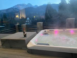 a hot tub on a deck with a view of a mountain at Skyline Villa with jacuzzi and sauna in Kościelisko