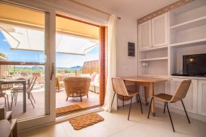 une cuisine et une salle à manger avec une porte coulissante en verre dans l'établissement Portisco Bouganville Seaside Charm Flat W/ Veranda, à Marina di Portisco