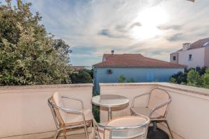 a patio with chairs and a table on a balcony at Apartments Tauzer in Mandre
