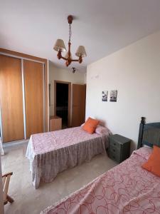 1 Schlafzimmer mit 2 Betten und einem Kronleuchter in der Unterkunft BAHIA alquiler solo para familias in Playa de Gandia